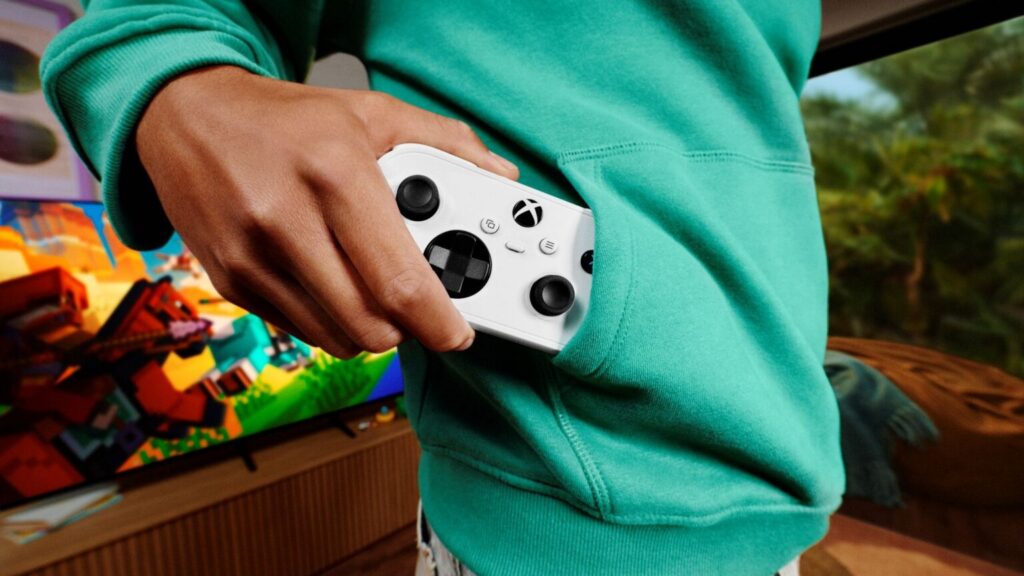 Xbox Nano Controller official photo showing the compact white controller beside a hoodie pocket